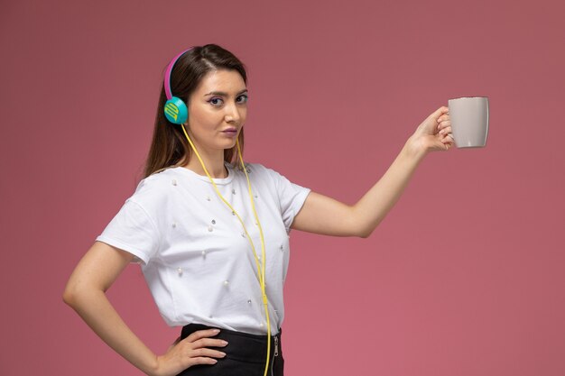 Vue De Face Jeune Femme En Chemise Blanche, écouter De La Musique Sur Le Mur Rose, Modèle De Couleur Femme Pose Femme