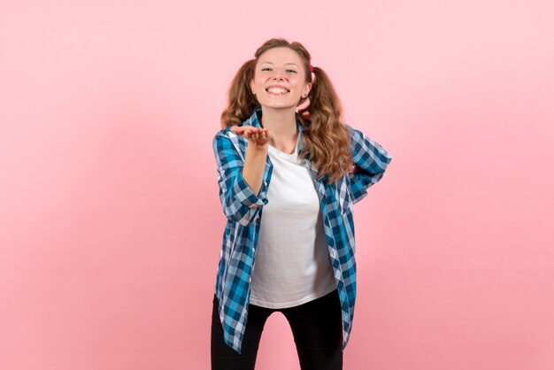 Vue de face jeune femme en chemise à carreaux bleu avec une expression heureuse sur fond rose émotion jeunesse fille kid mode modèle