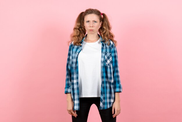 Vue de face jeune femme en chemise à carreaux bleu avec une expression triste sur fond rose femme émotions modèle mode filles couleur