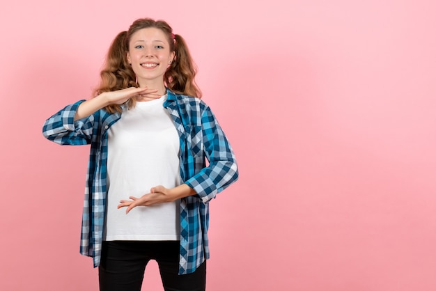 Vue de face jeune femme en chemise à carreaux bleu posant sur le fond rose femme enfant jeunesse couleur modèle d'émotion