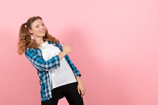 Vue de face jeune femme en chemise à carreaux posant sur fond rose modèle femme émotion couleur jeunesse enfant