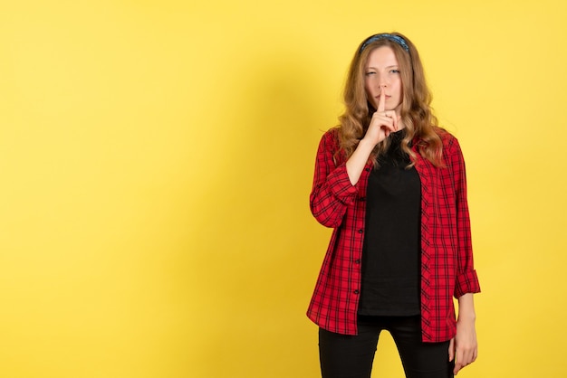 Vue de face jeune femme en chemise à carreaux rouge posant sur fond jaune modèle filles femme couleur émotions humaines femme