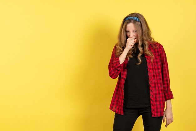 Vue de face jeune femme en chemise à carreaux rouge posant sur fond jaune modèle filles femme couleur émotions humaines