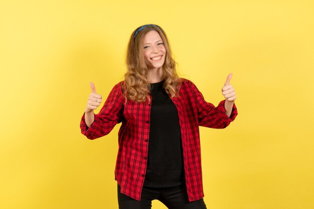 Vue de face jeune femme en chemise à carreaux rouge posant avec sourire sur fond jaune femme émotion humaine modèle fashion girl