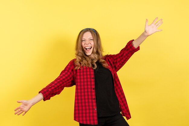 Vue de face jeune femme en chemise à carreaux rouge se réjouissant sur fond jaune femme émotion humaine modèle fashion girl