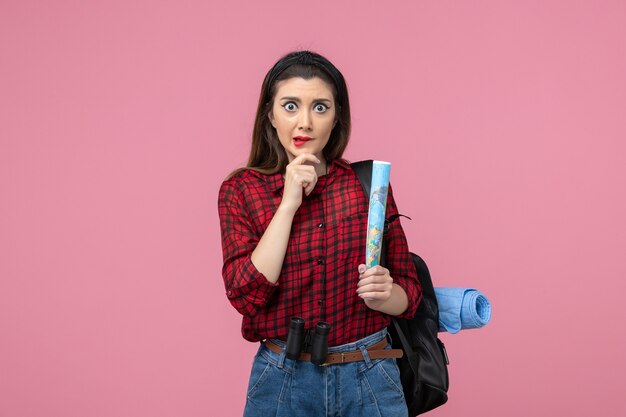 Vue de face jeune femme en chemise rouge avec carte sur la couleur de mode femme fond rose