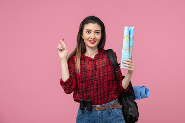 Vue de face jeune femme en chemise rouge avec carte sur la femme de mode couleur fond rose