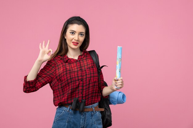 Vue de face jeune femme en chemise rouge avec carte sur la femme de mode couleur fond rose