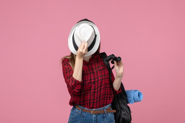 Vue de face jeune femme en chemise rouge avec chapeau sur le fond rose femme de couleur humaine