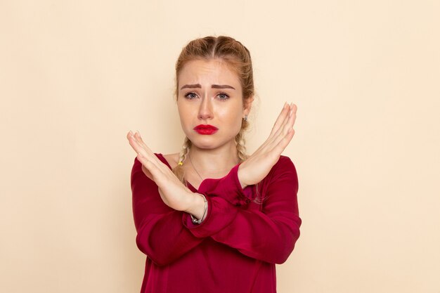 Vue de face jeune femme en chemise rouge signe d'interdiction de shwoign pleurer sur la photo de tissu femme espace crème