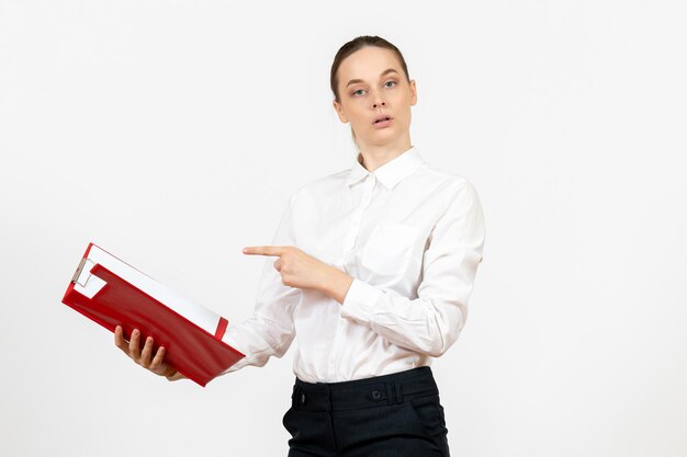 Vue de face jeune femme en chemisier blanc avec dossier rouge sur fond blanc bureau sentiment féminin émotion travail modèle