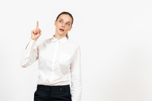 Vue de face jeune femme en chemisier blanc levant le doigt sur fond blanc bureau d'emploi femme sentiment modèle émotion