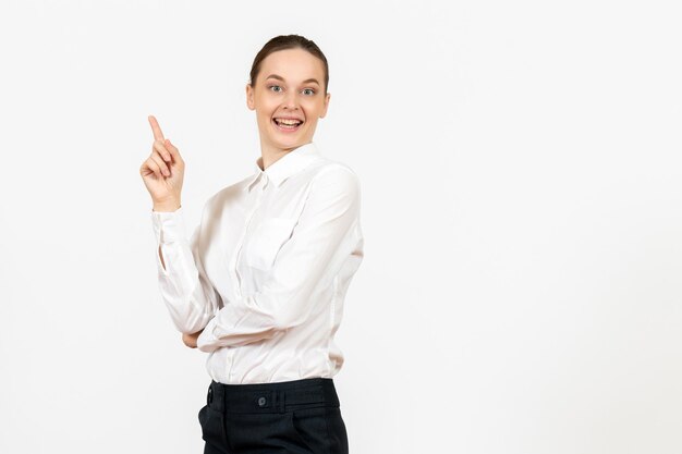 Vue de face jeune femme en chemisier blanc avec visage excité sur fond blanc clair bureau femme émotion sentiment travail modèle