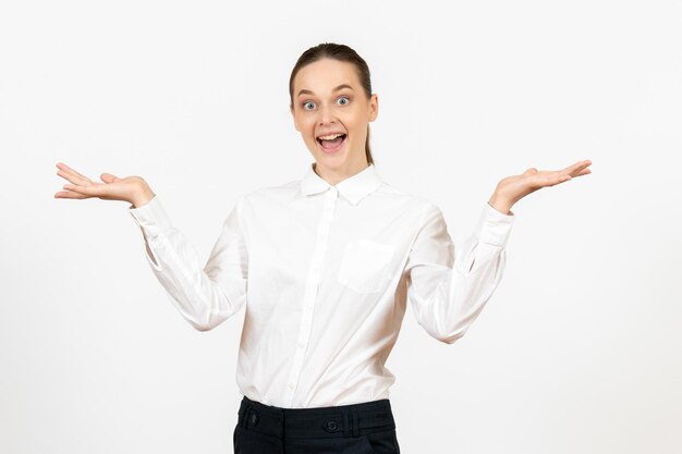 Vue de face jeune femme en chemisier blanc avec visage excité sur fond blanc travail de bureau modèle de sentiment d'émotion féminine