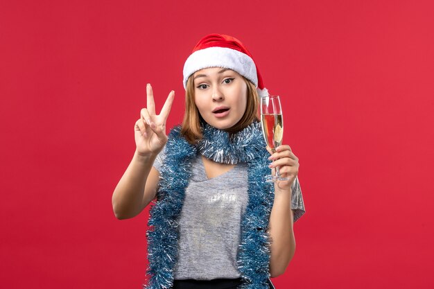 Vue de face jeune femme comptage montrant le nombre sur la couleur du mur rouge vacances de Noël