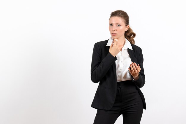 Vue de face jeune femme en costume classique strict faisant du maquillage sur fond blanc femme costume de travail entreprise travail féminin