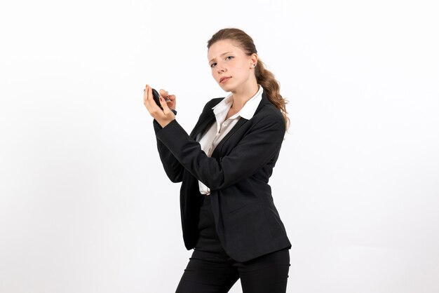 Vue de face jeune femme en costume classique strict faisant du maquillage sur fond blanc femme modèle emploi costume sérieux entreprise