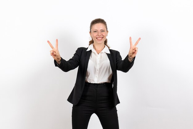 Vue de face jeune femme en costume classique strict posant et souriant sur fond blanc costume femme d'affaires travail travail femme