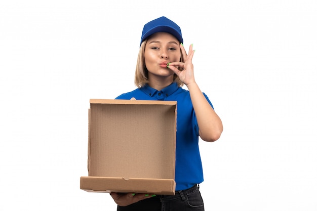 Une vue de face jeune femme courrier en uniforme bleu tenant le paquet de livraison de nourriture