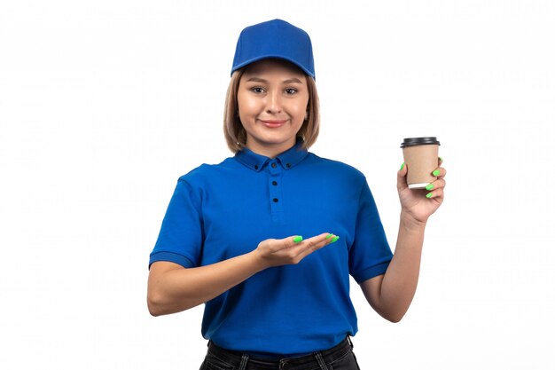 Une vue de face jeune femme courrier en uniforme bleu tenant une tasse de café