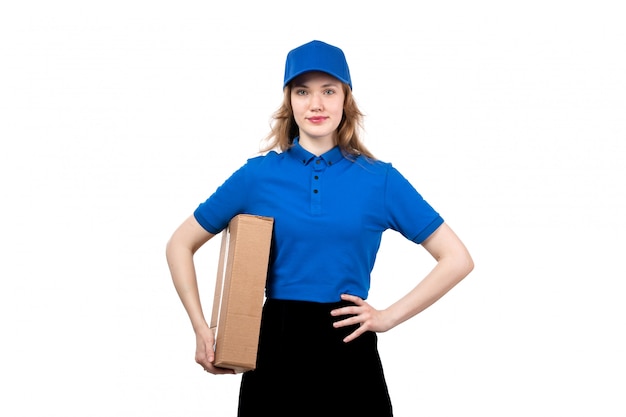 Une vue de face jeune femme courrier en uniforme tenant le colis de livraison souriant