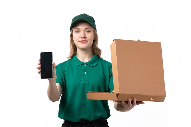 Une vue de face jeune femme courrier en uniforme vert holding smartphone et boîte à pizza ouverte