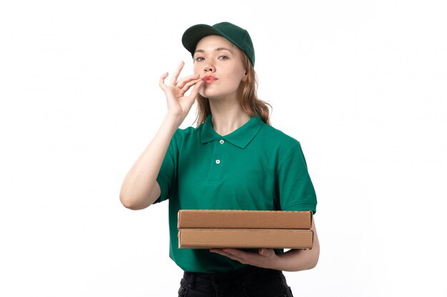 Une vue de face jeune femme courrier en uniforme vert tenant la boîte de livraison de pizza montrant signe savoureux