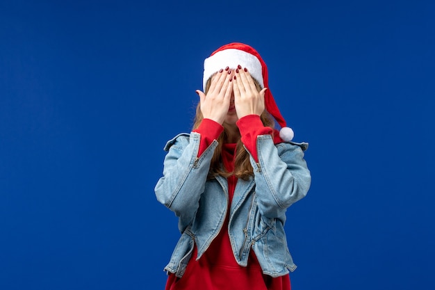 Vue de face jeune femme couvrant son visage sur fond bleu couleur d'émotion de Noël