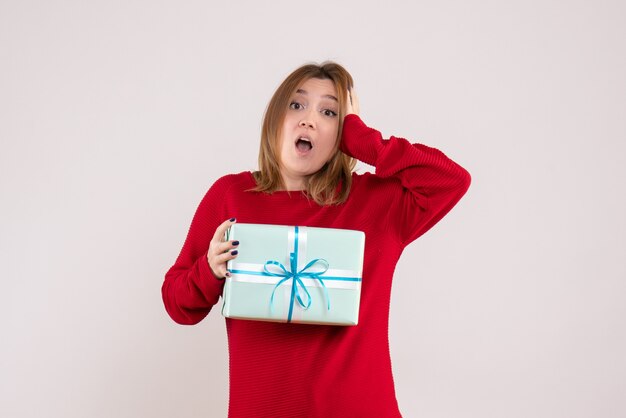 Vue de face jeune femme debout avec cadeau de Noël