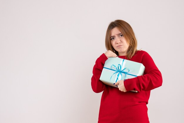 Vue de face jeune femme debout avec cadeau de Noël