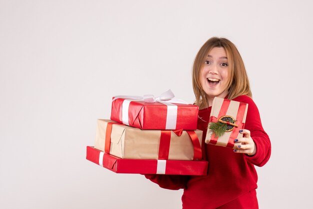 Vue de face jeune femme debout avec des cadeaux dans ses mains