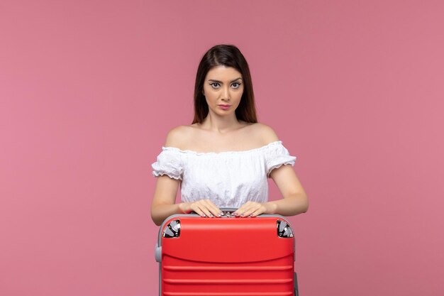 Vue de face jeune femme debout et se préparer pour les vacances sur le voyage de bureau rose voyage en mer à l'étranger voyage à l'étranger