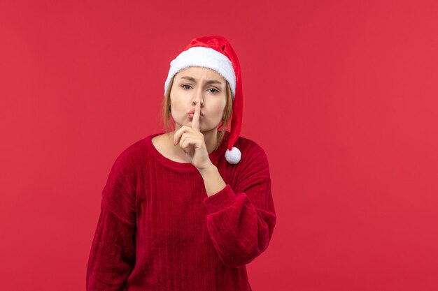 Vue de face jeune femme demandant à être calme, vacances Noël rouge