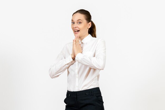 Vue de face jeune femme en élégant chemisier blanc juste debout sur fond blanc femme travail de bureau femme travailleuse