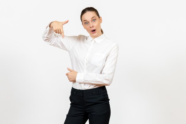 Vue de face jeune femme en élégant chemisier blanc avec visage excité sur fond blanc femme travail de bureau dame travailleuse