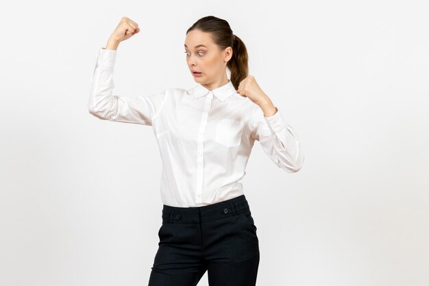 Vue de face jeune femme en élégant chemisier blanc avec un visage joyeux sur fond blanc femme travail de bureau dame travailleuse