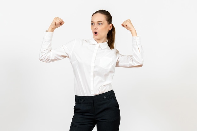 Vue de face jeune femme en élégant chemisier blanc avec un visage joyeux sur fond blanc femme travail de bureau dame travailleuse