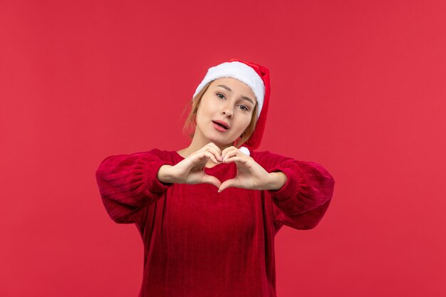 Vue de face jeune femme envoyant de l'amour, vacances de Noël rouge