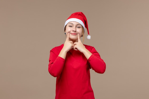 Vue de face d'une jeune femme essayant de sourire sur brown