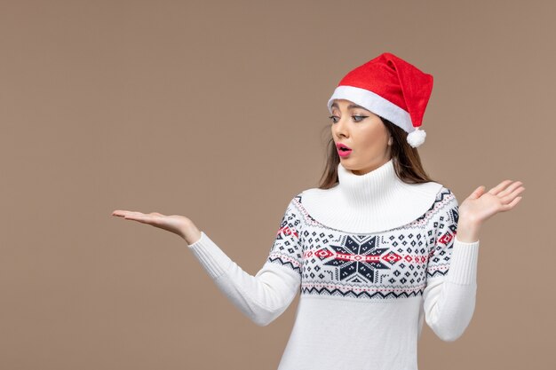 Vue de face jeune femme avec expression confuse sur le bureau marron vacances émotion Noël