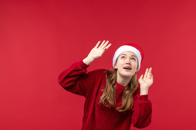 Vue de face jeune femme avec expression excitée sur le bureau rouge vacances de Noël rouge