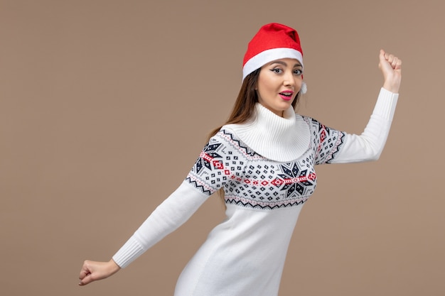 Vue de face jeune femme avec une expression excitée sur fond marron nouvel an émotion noël