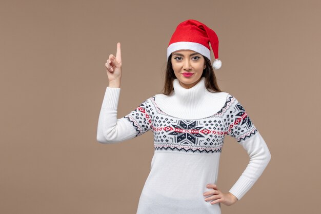 Vue de face jeune femme avec une expression souriante sur fond marron nouvel an émotion noël