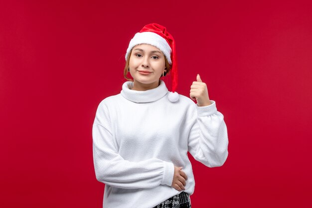 Vue de face jeune femme avec une expression souriante sur fond rouge