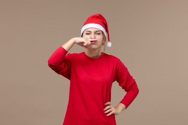 Vue de face d'une jeune femme faisant de la moustache sur brown