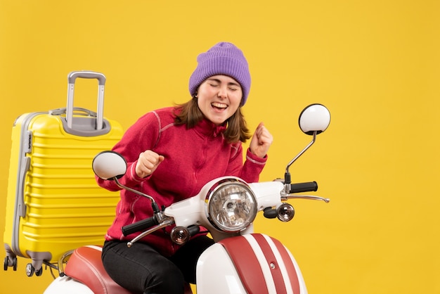 Vue de face jeune femme heureuse sur cyclomoteur