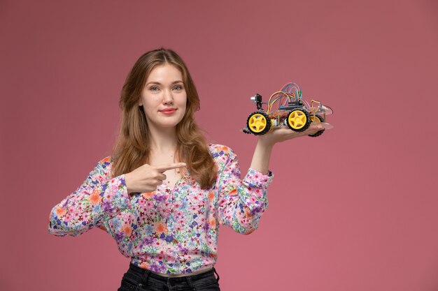 Vue de face jeune femme illustre jouet voiture
