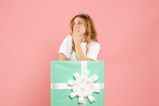 Vue de face jeune femme à l'intérieur de la boîte cadeau bleue