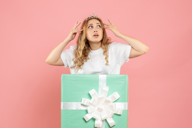 Photo gratuite vue de face jeune femme à l'intérieur de la boîte cadeau bleue