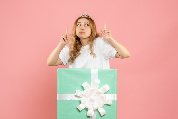 Vue de face jeune femme à l'intérieur de la boîte cadeau bleue